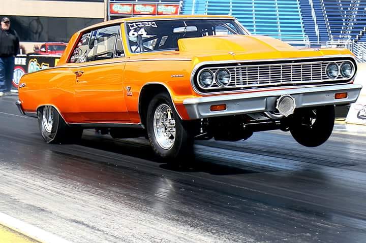An Orange Color Chevelle Car Riding on Road