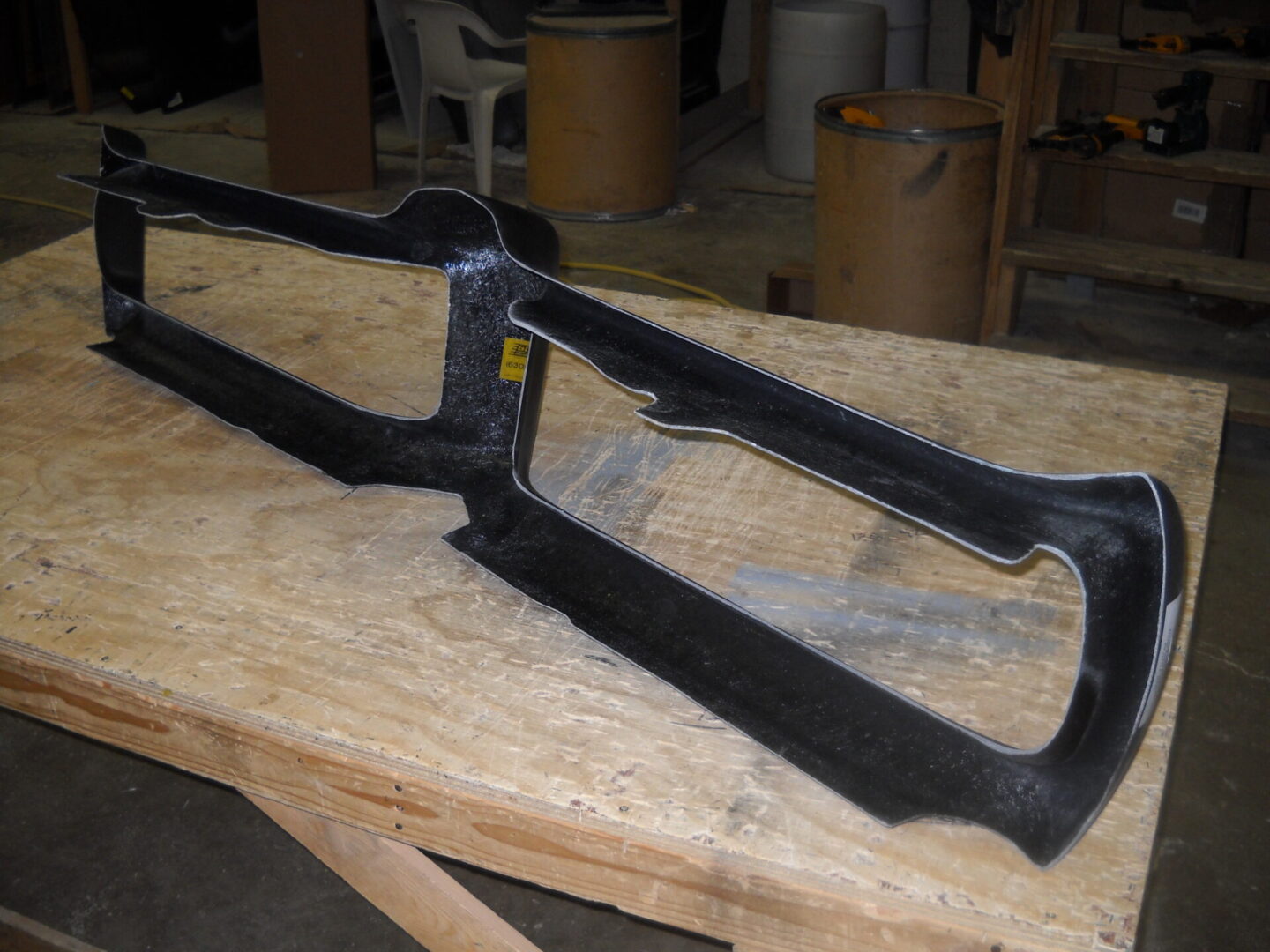 Black plastic car dashboard bezel on workbench