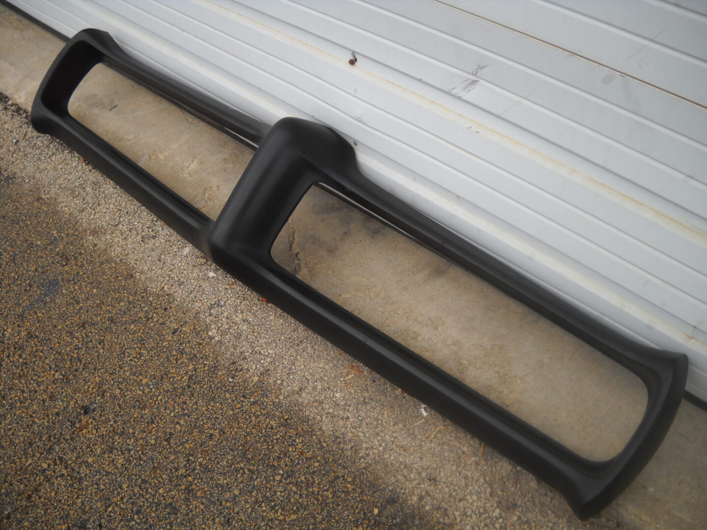 Black vehicle bumper cover on concrete ground