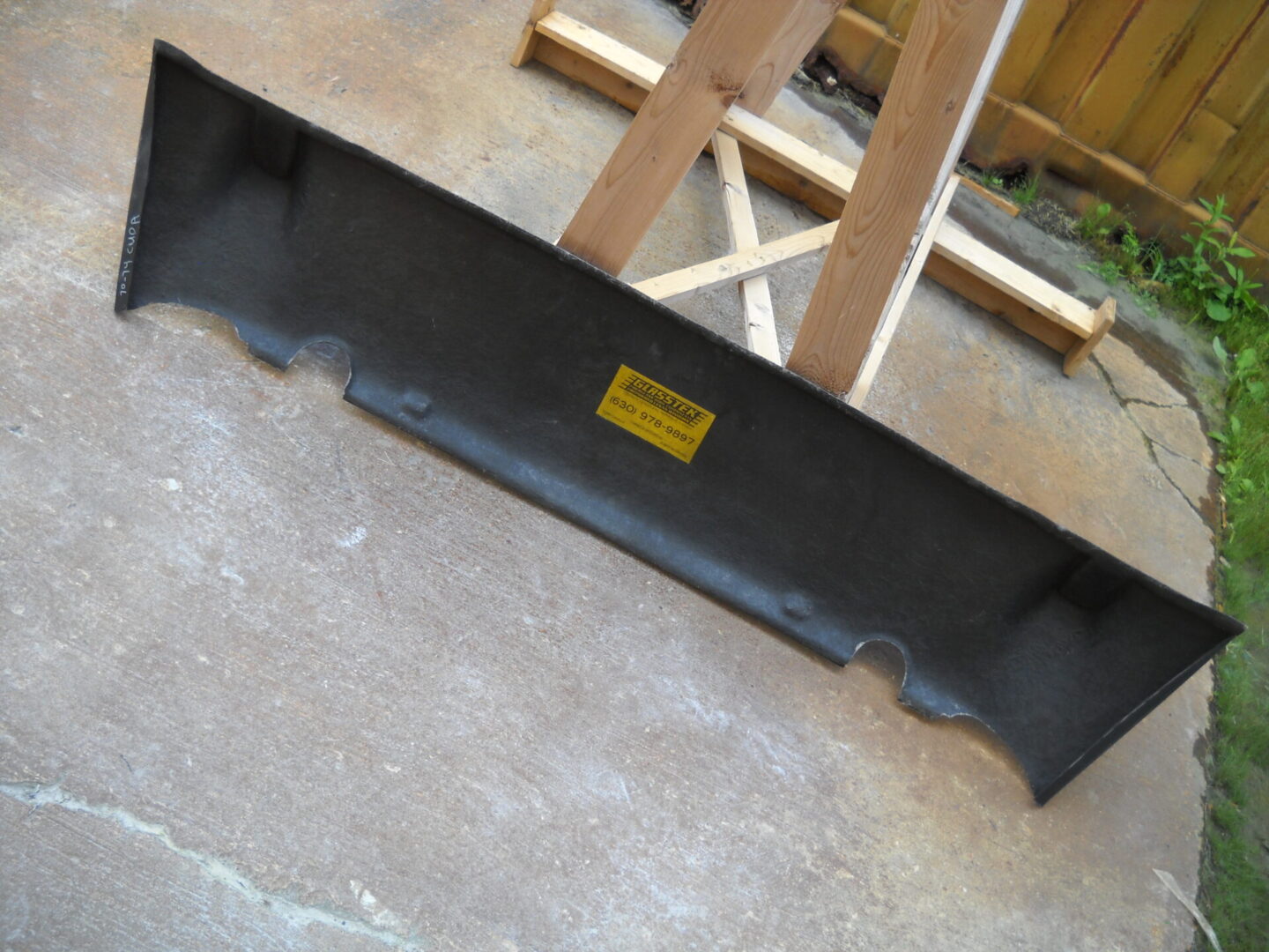 Black car rear bumper spoiler on concrete