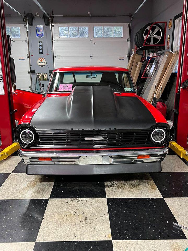 A red and black color vintage car at a garage