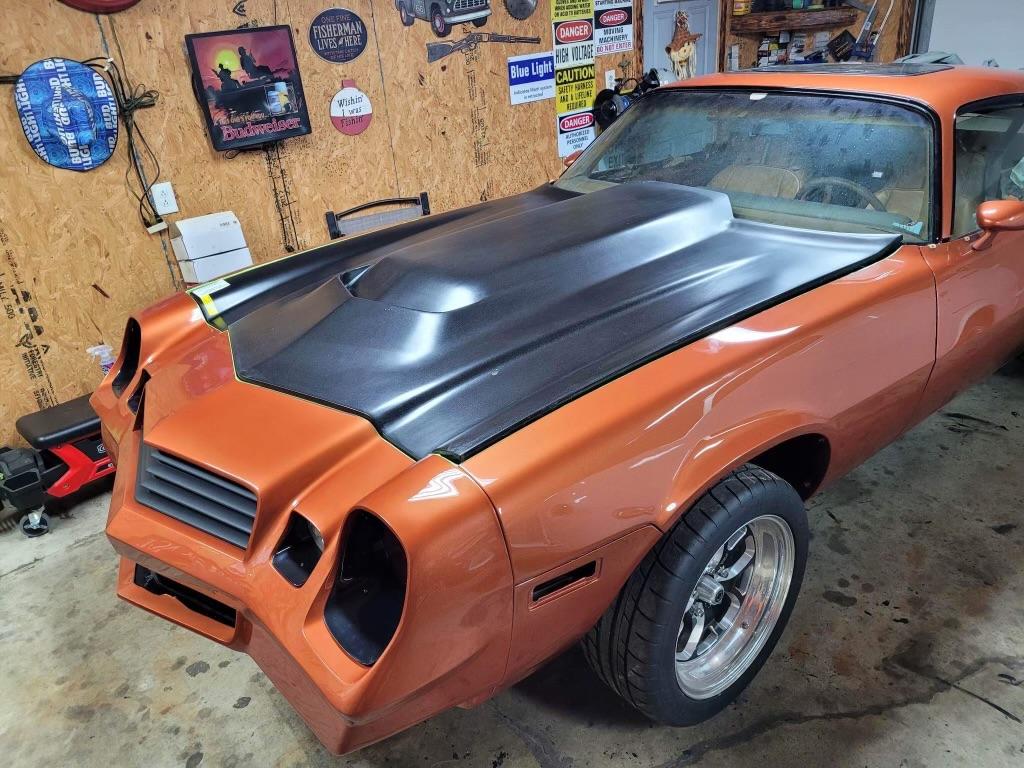An orange and black color modified car at garage